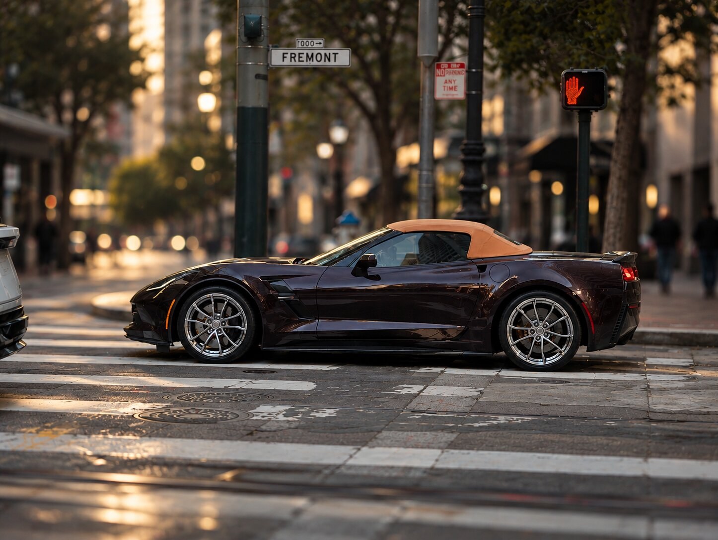 Dark Black Rose Corvette convertible with a camel soft top at Market and Fremont in San Francisco